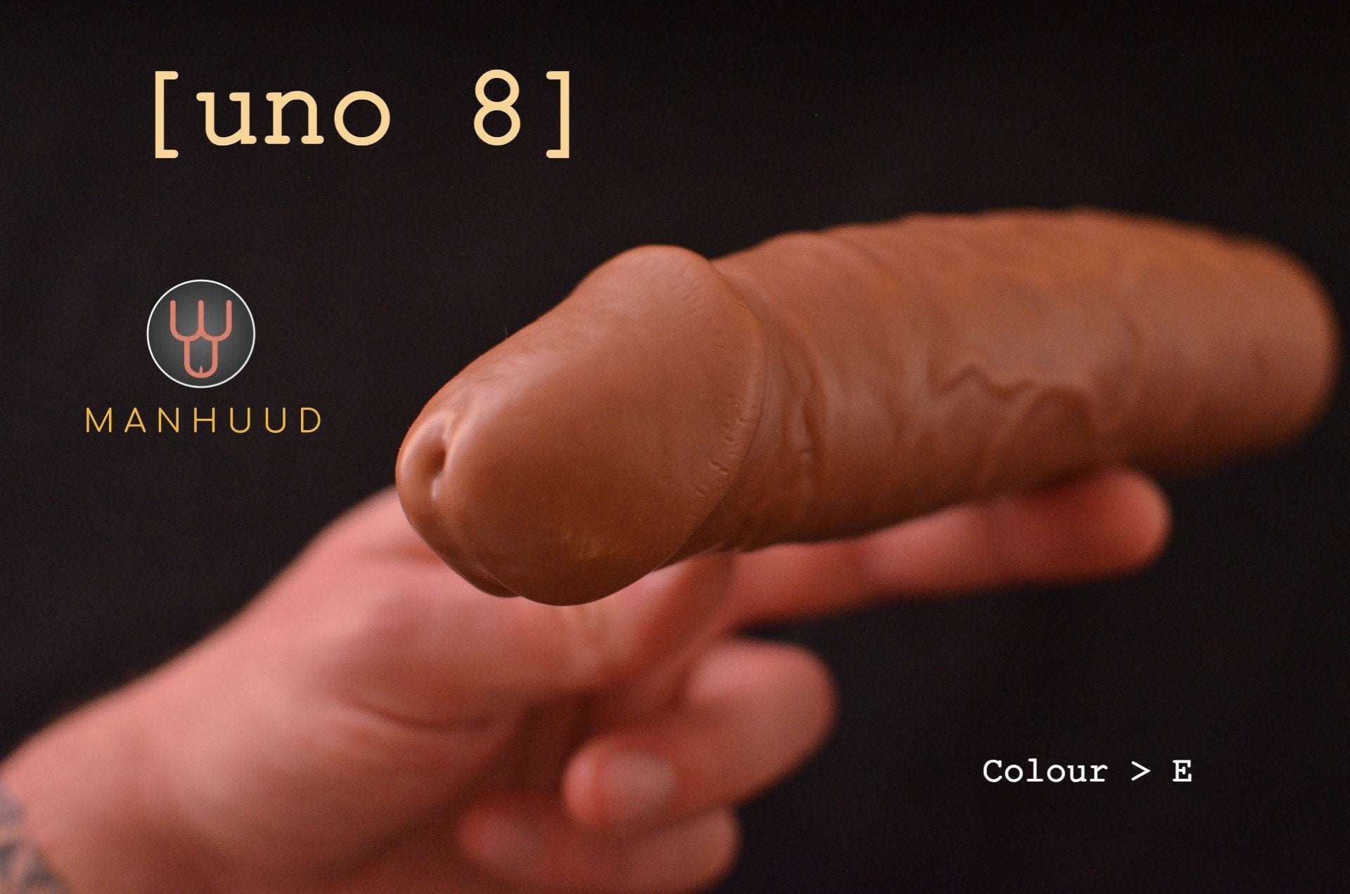 A hand displaying a MANHUUD "uno 8" silicone penis sleeve